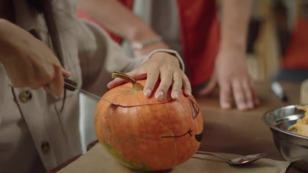 Una joven está empezando a tallar una calabaza para Halloween — Vídeo de stock