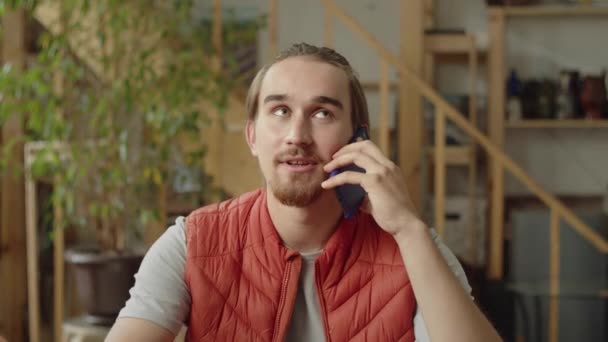 Молодой человек разговаривает со своим другом по телефону — стоковое видео