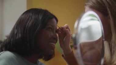 Genç bir bayan arkadaşına yağlı bez çiziyor.