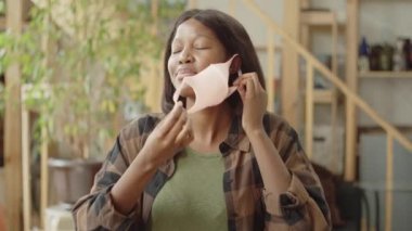 Genç bir kadın koruyucu bir maske takıyor.