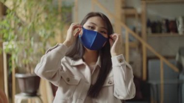 Genç bir kadın koruyucu bir maske takıyor.