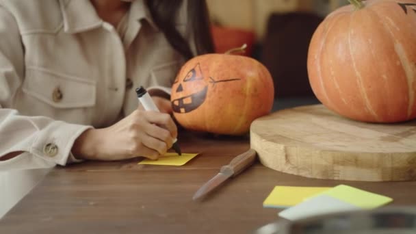 Amigos escriben nombres para sus calabazas de halloween — Vídeos de Stock