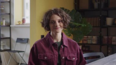 Genç ve güzel bir bayan kameraya bakıyor ve gülümsüyor. Yüksek kalite 4k görüntü