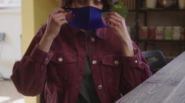 Güzel bir bayan yüzüne koruyucu bir maske takıyor. Yüksek kalite 4k görüntü