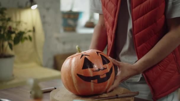 Seorang pemuda memotong bagian atas labu halloween — Stok Video