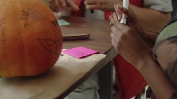 Friends stick name stickers on Halloween pumpkins — Stock Video