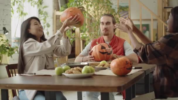 Vänner tittar och pratar om sina målade halloween pumpor — Stockvideo