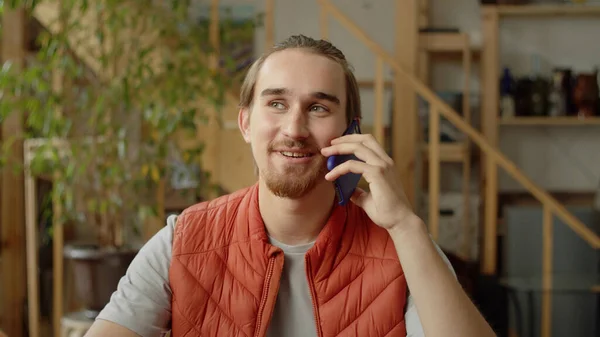 Um homem bonito está a falar com o amigo ao telefone. — Fotografia de Stock