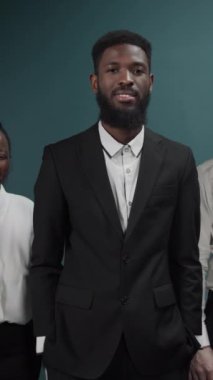 Arkadaşlar kucaklaşıp yeşil duvarın üstünde eğleniyorlar, kameraya poz veriyorlar.