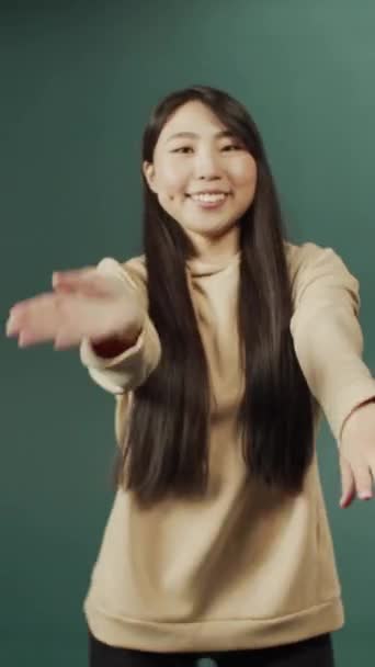 Ung vacker kinesisk sportig kvinna bär beige tröja show populära dans rörelser — Stockvideo