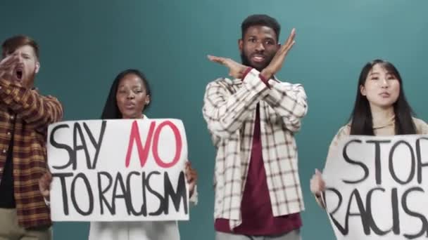 Группа молодых активистов протестует против дискриминации плакатом "Остановить расизм" — стоковое видео