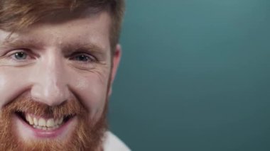 Genç doktor steteskop ve sağlık ceketi giyip yeşil arka plana gülüyor, heyecanlı bir yüz ifadesi takınıyor.