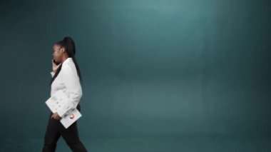 Irklar arası bir grup ellerinde belgelerle yürüyüp telefonda konuşuyor.