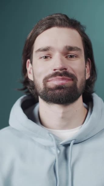 Zorgeloos aantrekkelijke man met donker haar en baard oprecht glimlachend — Stockvideo