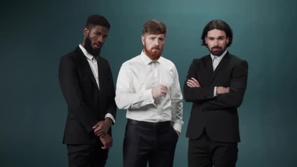 Tre män vänner poserar och tittar på kameran på allvar — Stockvideo