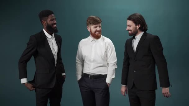 Drie mannen in smoking poseren, lachen en kijken raar naar de camera. — Stockvideo