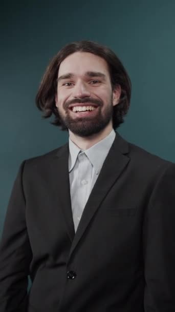 Sorrindo cara alegre em um terno preto e camisa cinza tirando os óculos — Vídeo de Stock