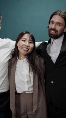 Farklı milletlerden bir grup genç, mutlu bir şekilde sarılıyorlar.