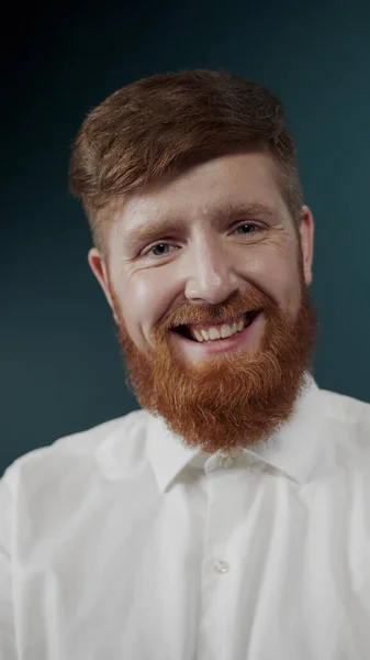Портрет рыжего бородатого парня в белой классической футболке, делающего лица — стоковое фото