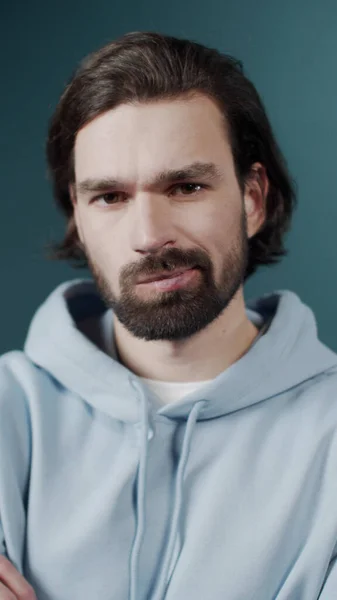 Isolerad mörkhårig kille förvirrad känner tvivel medan gör val, klädd i casual hoodie — Stockfoto