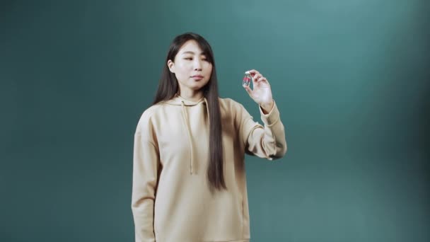 Eine attraktive junge Asiatin rät von dieser Ampulle mit Impfung gegen Coronavirus ab und zeigt den Daumen nach unten — Stockvideo