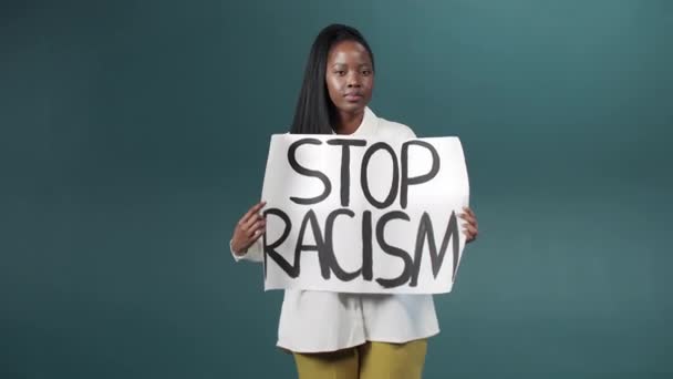 Atraktivní africká dáma ukazuje plakát, vyzývá všechny, aby zastavili rasismus a odstěhovali se — Stock video