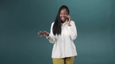 Yakışıklı bir Afrikalı kadın telefonda arkadaşıyla duygusal olarak konuşuyor.