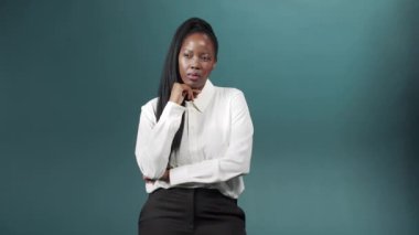 Genç ve çekici bir kadın ciddi olmak için kollarını göğsünde kavuşturuyor ve işini düşünüyor.