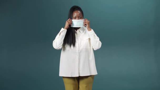 A attractive cheerful african lady is putting on medical mask for health protection and prevention during the virus outbreak, epidemic and infectious diseases — стоковое видео