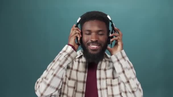 En afrikansk ung man i vit skjorta lyssnar på musik och dans. — Stockvideo