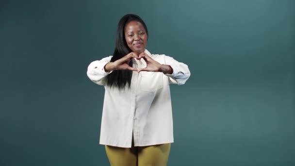 A handsome african woman is showing a heart from her hands — Stock Video