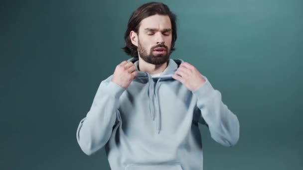 Isolated Dark-haired guy confused feels doubt while makes choice, dressed in casual hoodie — Stock Video