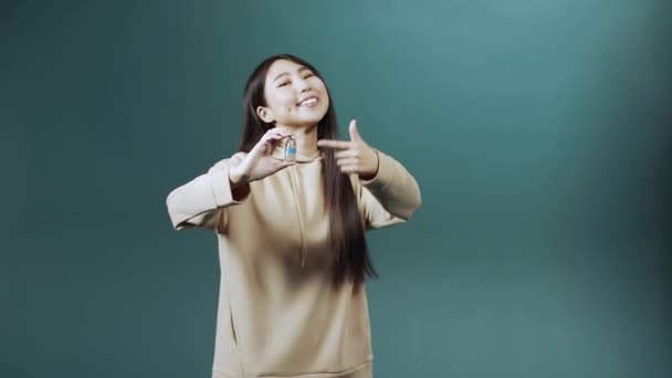 Una giovane donna asiatica carina sta mantenendo una fiala di vaccino contro il coronavirus e mostrando un pollice in su — Video Stock