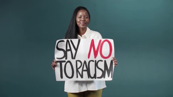 Güzel Afrikalı Amerikalı kız gururla elinde ırkçılığa hayır işareti taşıyor. — Stok video