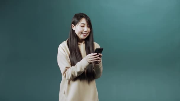 Un guapo asiático señora está utilizando un teléfono y charlando con su amigo — Vídeo de stock