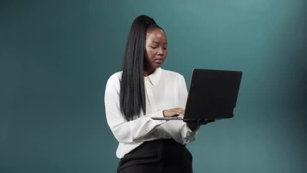 Красива дівчина в офісному костюмі використовує свій ноутбук для спілкування з друзями та бізнесом — стокове відео