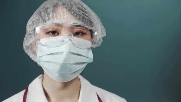 Втомлена жінка в медичній формі фіксує окуляри і дивиться на камеру — стокове відео