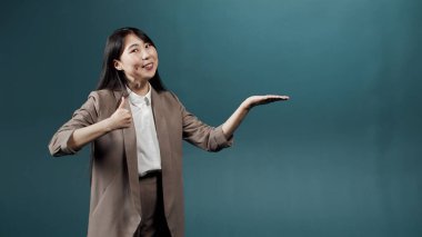 Uzun siyah saçlı yakışıklı Asyalı bir bayan ürününün reklamını yapıyor.