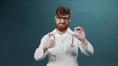 Çekici genç bir doktor iki ampulü aşıyla karşılaştırır ve en iyisini gösterir.