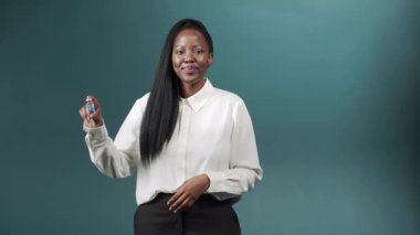 Genç ve tatlı Afrikalı bir bayan Coronavirus 'a karşı bir ampul aşı tutuyor ve baş parmağını kaldırıyor.