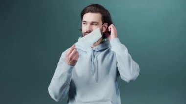 Sakallı bir adam yüzüne koruyucu bir maske takar.