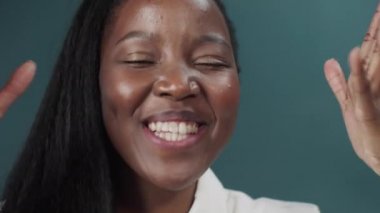 Uzun saçlı, dans eden bir Afrikalı kadının yakın plan portresi.