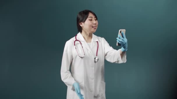 Genç ve çekici bir doktor hastasıyla internette video danışmanlığı yapıyor. — Stok video