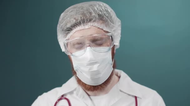 Yorgun bir adam tıbbi bir maske ve şapka takıyor. — Stok video
