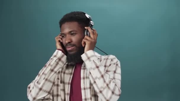 En afrikansk ung man i vit skjorta lyssnar på musik och dans. — Stockvideo
