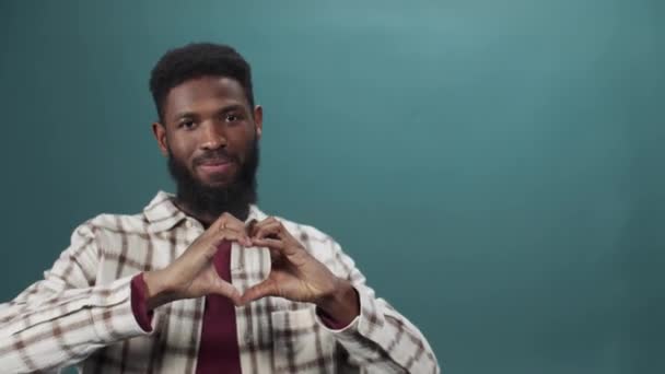 En vuxen afrikansk man visar ett hjärta från sina händer — Stockvideo