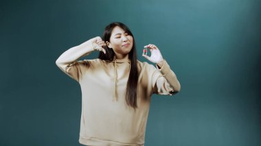 Çekici genç Asyalı bir kadın bu ampulü koronavirüse karşı aşıyla tavsiye etmez ve baş parmağını aşağı gösterir.