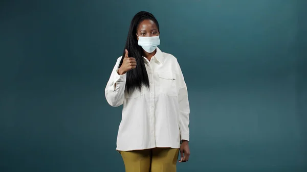Uma senhora africana alegre e atraente está colocando máscara médica para proteção e prevenção da saúde durante o surto de vírus, epidemia e doenças infecciosas — Fotografia de Stock