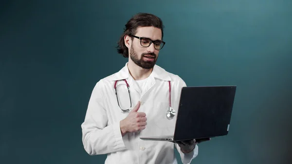 Mladý černě vousatý doktor se svým pacientem na internetu provádí videokonferenci. — Stock fotografie