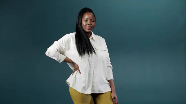 Une belle jeune femme noire entre et commence à poser en souriant à la caméra Images De Stock Libres De Droits